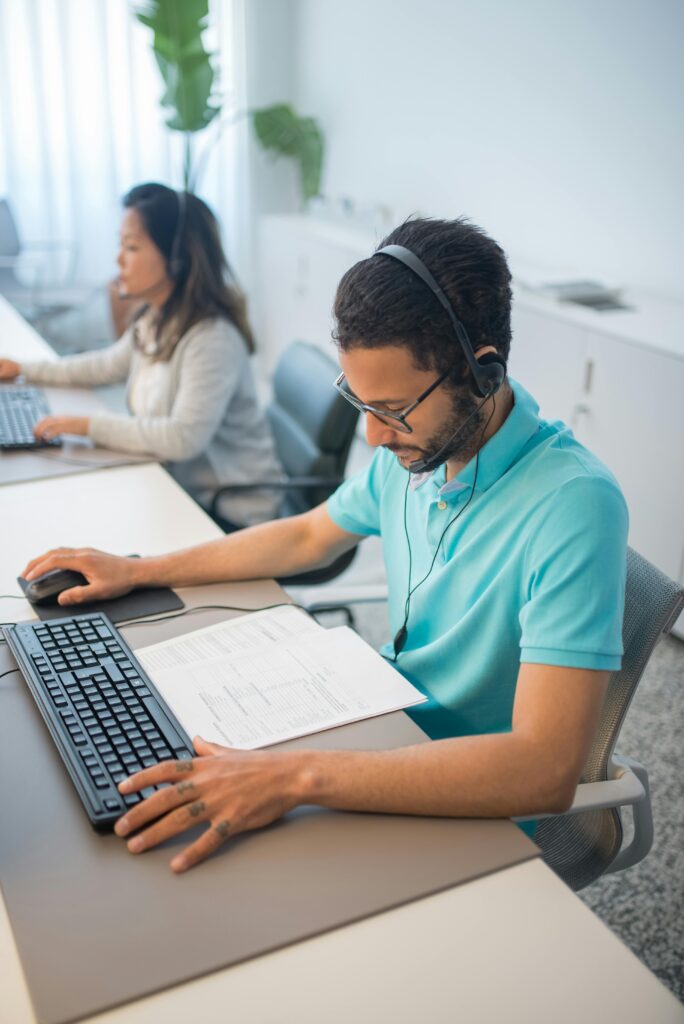 Two professionals working in a modern office setting, focusing on documents and computers, fostering productivity.